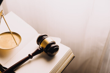 Justice and law concept.Male judge in a courtroom with the gavel, working with, computer and docking keyboard, eyeglasses, on table in morning light