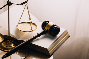 Justice and law concept.Male judge in a courtroom with the gavel, working with, computer and docking keyboard, eyeglasses, on table in morning light