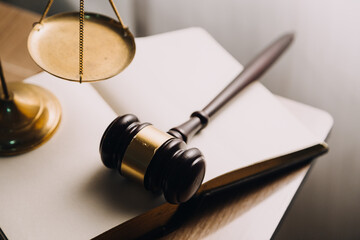 Justice and law concept.Male judge in a courtroom with the gavel, working with, computer and docking keyboard, eyeglasses, on table in morning light