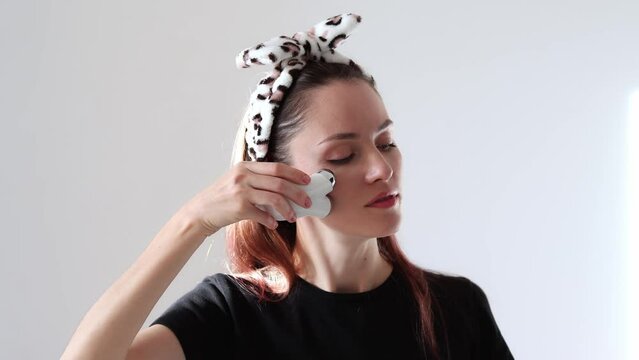 Happy woman doing facial microcurrents. Facial massage at home with a device with currents