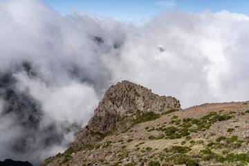 Fototapeta na wymiar volcanic cliff stands out of clouds north of Miradouro de Areeiro peak, Madeira