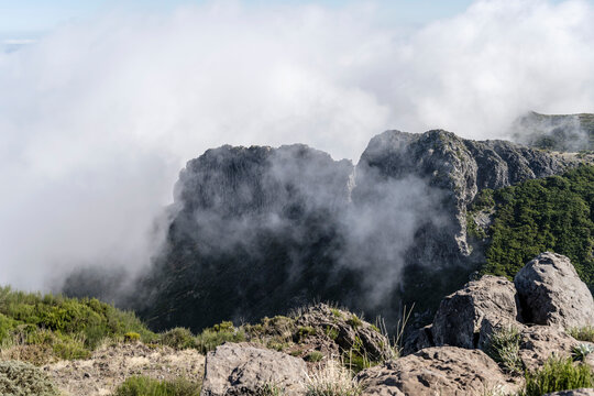 clouds engulfing volcanic cliffs at Miradouro de Areeiro peak, Madeira