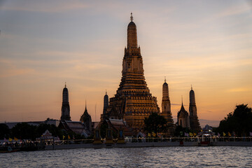 Fototapeta premium Sonnenuntergang in der Hauptstadt Thailands, Bangkok, am Fluss mit Blick auf die Touristenattraktion, den Tempel Wat Arun