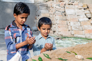orphan children praying at the grave