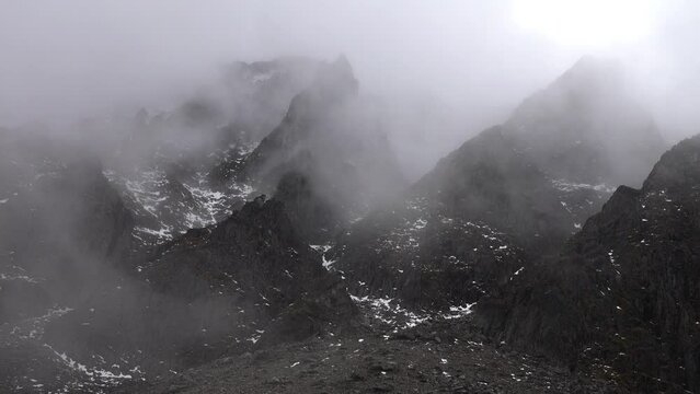 Geotectonics. Many small volcanic cones in Field of former volcanic activity, clouds over volcanic upheaval, igneous rocks. Such mountains look like sawback. volcanic area. Sayan Mountains, Siberia.