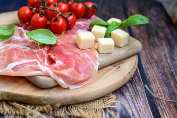 Slices Of  Traditional Italian antipasti mortadella Bolognese,salame Milano, parmesan cheese  and prosciutto crudo   on a wooden  cutting board.