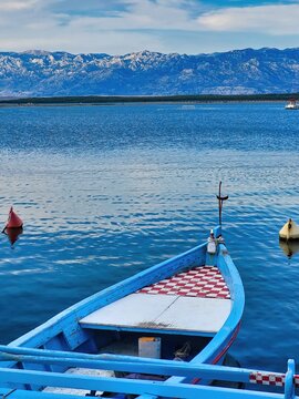 Beautiful View From A Bow Of Yacht At Seaward. An Adventurous Person Doing Windsurfing With A Lot Of Speed  On A Lake In The Afternoon. Sail On An Island In The Sea During The Holidays