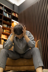 upset woman in depression sits holding her head in her hands