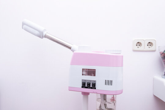 A pink and white roller machine to apply treatments in a beauty center