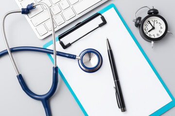 Doctor desk with stethoscope and clipboard with pen, online healthcare consultation