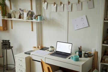 Background image of cozy artists workplace with jewelry designs on laptop screen at desk, copy space