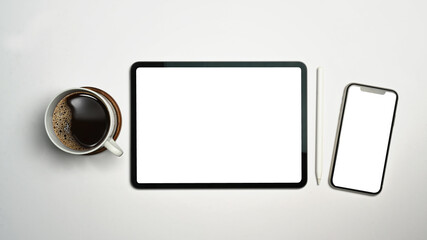 Digital tablet, smart phone, stylus pen and cup of coffee on white background. Empty screen for advertise design