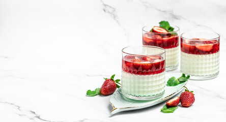 Italian panna cotta dessert with strawberry and mint on a light background. Summer yogurt dessert....