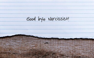 Lined sheet paper on old vintage wood background with handwritten text GOOD BYE NARCISSIST ,...