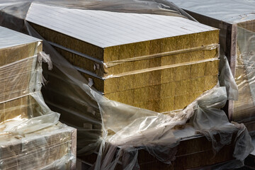 Insulated panels for a frame house are stored at the construction site. Preservation of heat and...