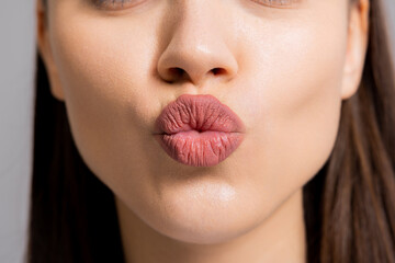 Close up shot selective focus on woman's lips sending kiss a camera.