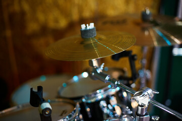 Part of a drum kit against a black background, percussion instrument, snare drum, bass drum, hi-hat, beat set on stage. Orchestral percussion instruments in light colors close-up