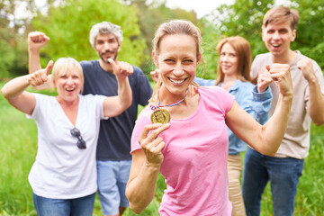 Frau mit Sieger Medaille jubelt mit geballten Fäusten