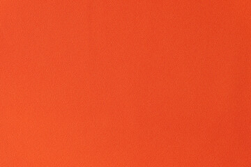 Unicolorous bright orange fabric as background.