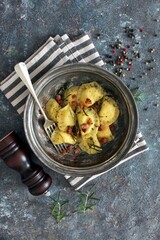Homemade ravioli with potato and ricotts cheese served with crispy bacon. Top view with copy space. 
