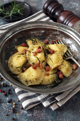 Homemade ravioli with potato and ricotts cheese served with crispy bacon. Top view with copy space. 