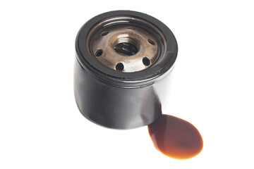 Car oil filter with a puddle of engine oil isolated on white background