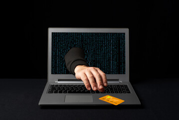 A cybercriminal reaching through a laptop to steal an online shopper's credit card. Internet scams