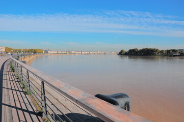 Calm river view from a dock with a blue sky at the horizon