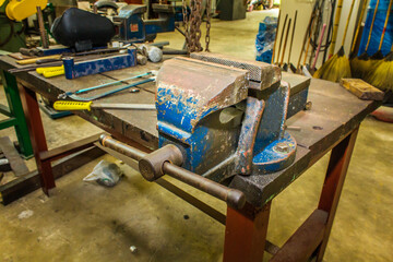 Close up of vice clamp in garage. Heavy tool concept. Garage workshop with tools equipment. Bench Vise clamp on the table