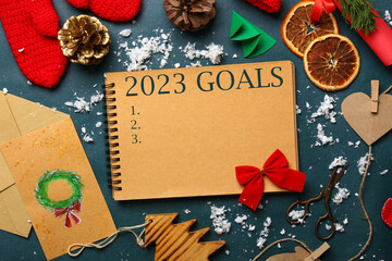 Notebook with blank to-do list for year 2023 and Christmas decor on dark background
