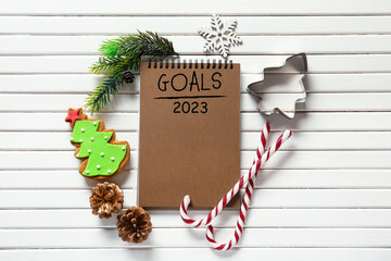 Notebook with blank to-do list for year 2023 and Christmas decor on white wooden background