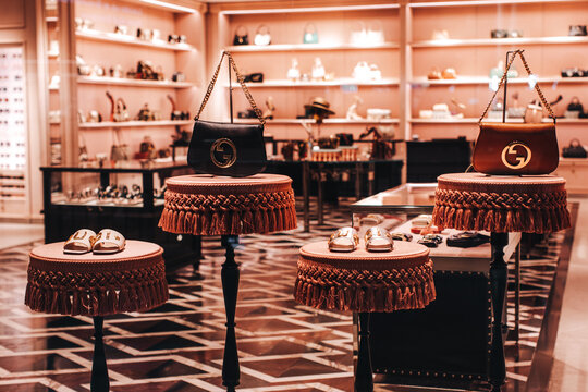 Women's fashion accessories handbags and shoes of the famous GUCCI brand on the display in the boutique. Gucci is an Italian luxury brand of fashion and leather goods.