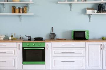 Interior of kitchen with modern green household appliances