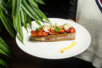 delicious bruschetta with cheese, meat, vegetables in a restaurant
