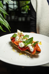 delicious bruschetta with cheese, meat, vegetables in a restaurant

