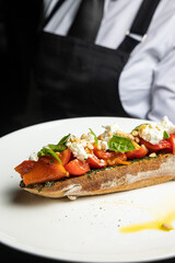 delicious bruschetta with cheese, meat, vegetables in a restaurant
