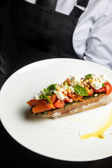 delicious bruschetta with cheese, meat, vegetables in a restaurant
