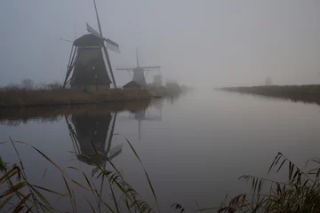 Foto auf Leinwand Windmills of Kinderdijk in autumn and fog © Wim