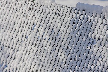 Schnee auf Maschendrahtzaun