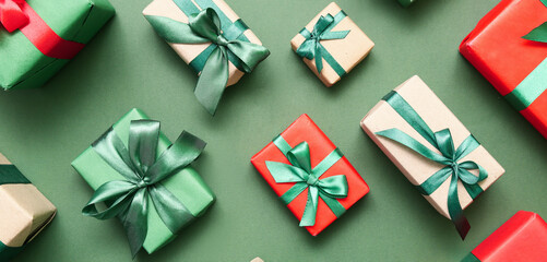 Many beautiful Christmas gifts on green background, flat lay