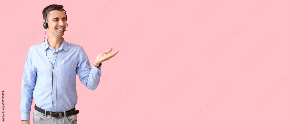 Poster male technical support agent showing something on pink background with space for text