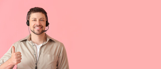 Male technical support agent showing thumb-up on pink background with space for text