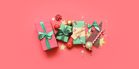 Gift boxes with Christmas decor on red background, flat lay