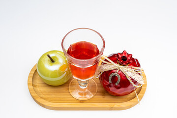 White background with an apple, pomegranate and a glass of wine on a wooden tray as a Rosh Hashanah concept. Pomegranate, Nar Bayramı New Harvest Festival