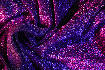 Fototapeta na wymiar Shiny purple fabric in neon light as background