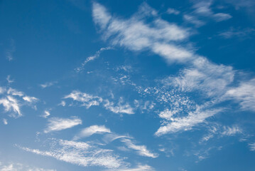 Naklejka na ściany i meble Whispy white clouds against blue sky in daylight