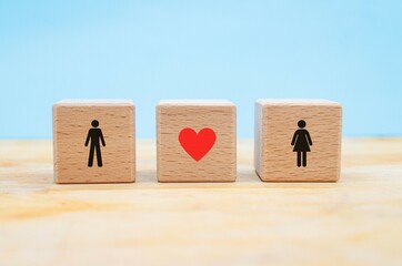 symbols of man and woman with concept of love or infatuation represented in three wooden blocks on a blue background with copy space
