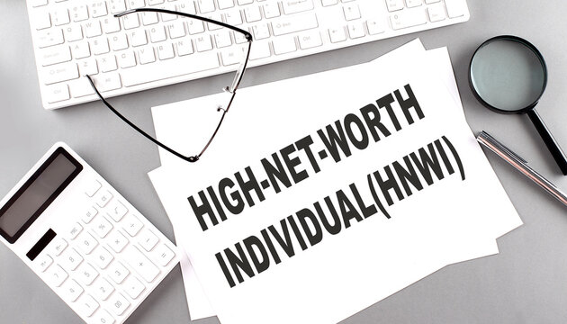 HNWI High Net Worth Individuals Text On Paper With Keyboard, Calculator On Grey Background