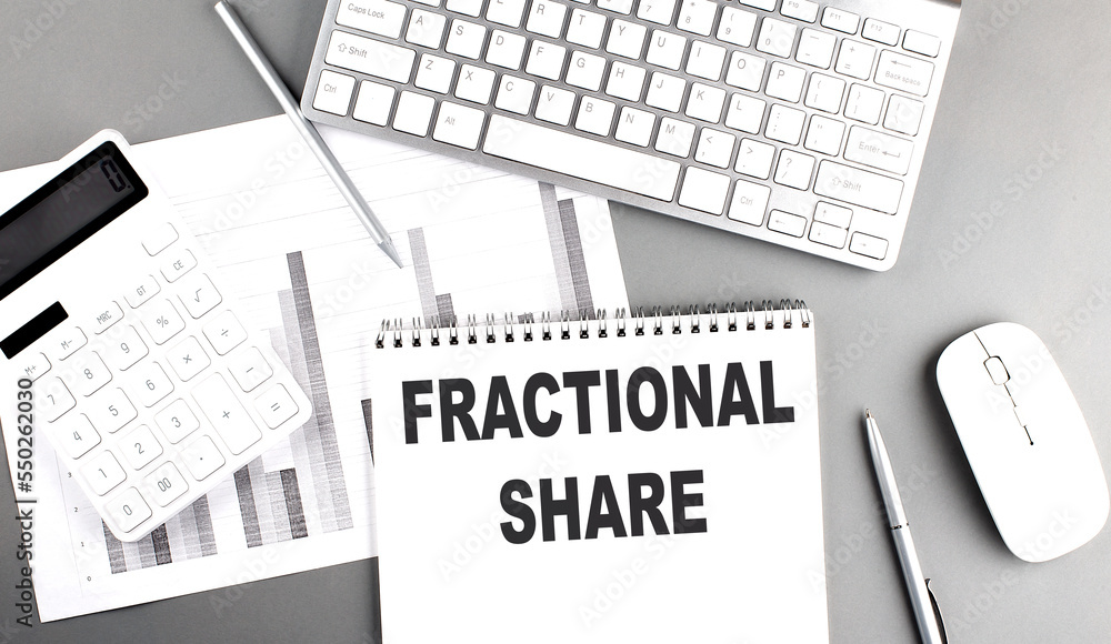 Poster fractional share text written on notebook on grey background with chart and keyboard, business conce