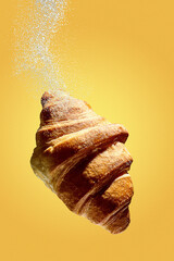 Croissant in levitation with flour or powdered sugar. Freshly baked croissant for breakfast with pastries. Creative flying food poster